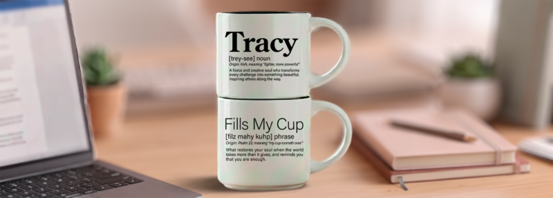 Fills My Cup name mug set reading Tracy Fills My Cup, two 14-ounce white stackable mugs in Word Story Style on a writer’s desk with a laptop and notebooks