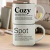 Cozy + Spot mug set in Timeless Italic font, two 14-ounce white stackable mugs with white interiors and Meaningful Word Story Style definitions on a writer’s desk